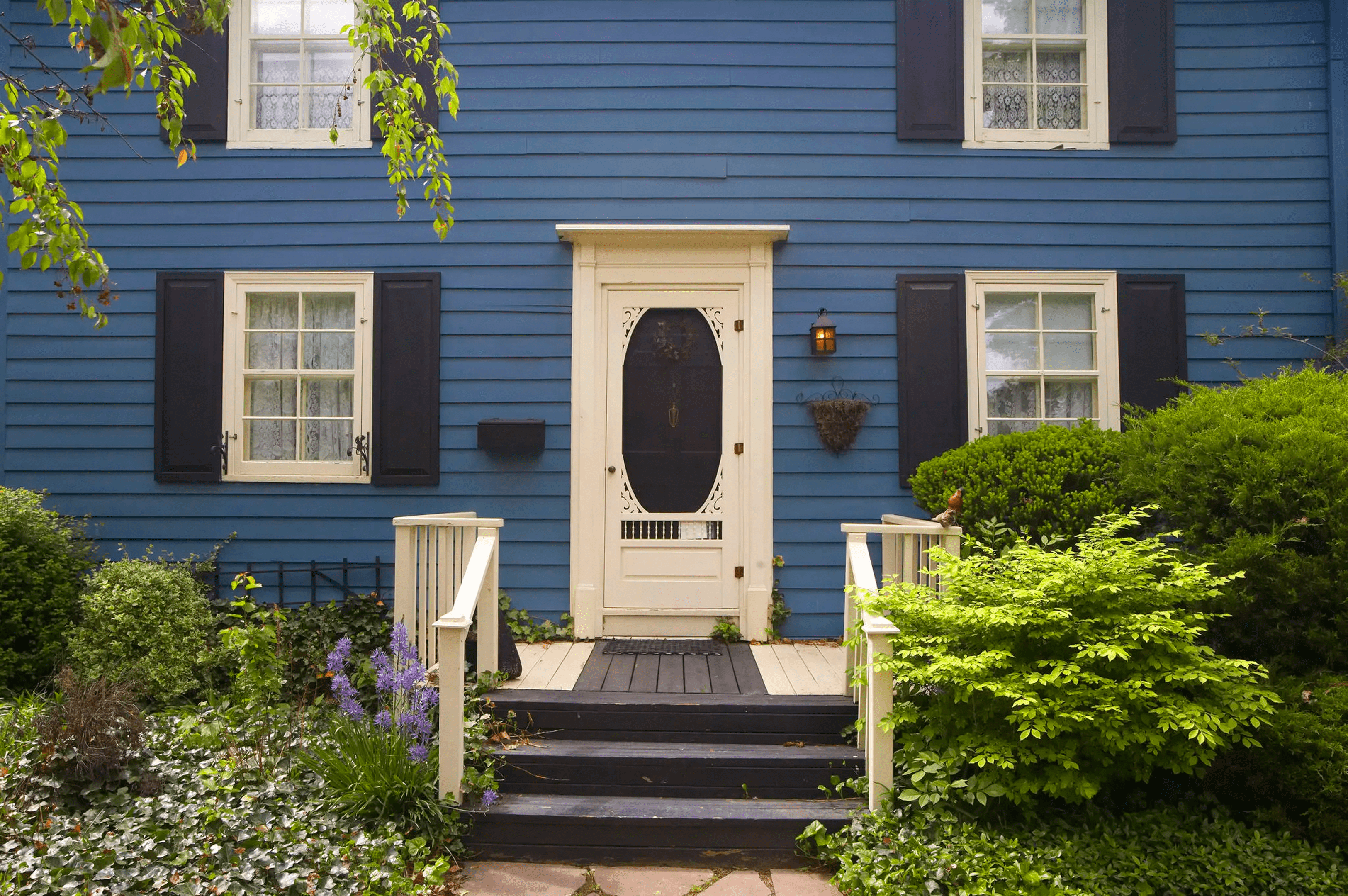Blue house front entrance with white door and porch.