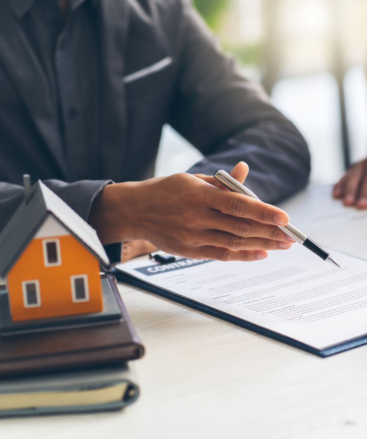 Real estate agreement and house model on table